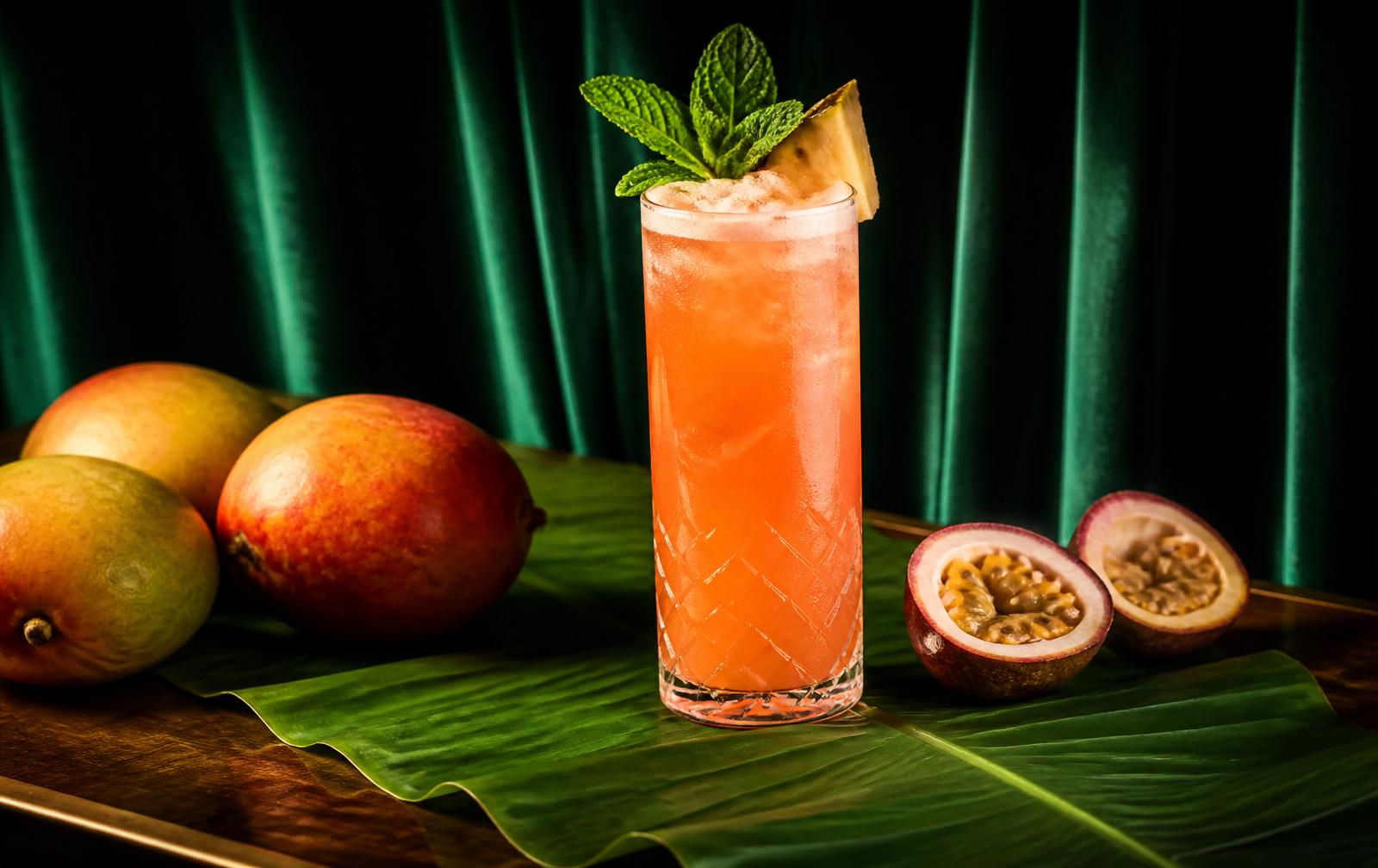 Tropical cocktail on a banana leaf against emerald velvet